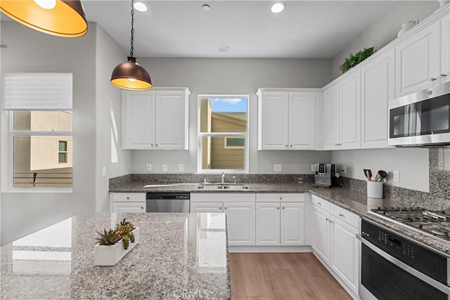 27422 Pioneer Ct, Valencia, CA 91381 - kitchen with appliances with stainless steel finishes, white cabinetry, light wood finished floors, recessed lighting, and decorative light fixtures