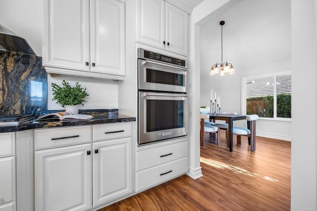 1592 Hawk View Dr, Encinitas, CA 92024 - kitchen with stainless steel double oven, white cabinetry, dark wood-style flooring, and a chandelier
