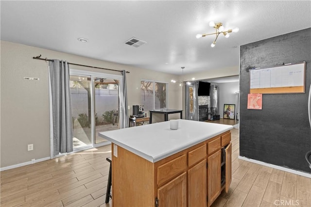 1142 Juniper Ct, San Jacinto, CA 92582 - kitchen with light wood-style floors, a center island, a chandelier, and a breakfast bar