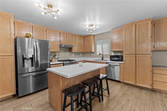 1142 Juniper Ct, San Jacinto, CA 92582 - kitchen with appliances with stainless steel finishes, under cabinet range hood, light wood-style floors, light countertops, and a chandelier