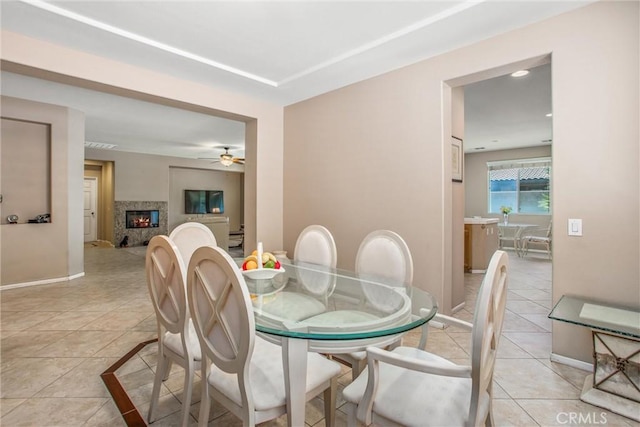 83315 Stagecoach Rd, Indio, CA 92203 - dining area with light tile patterned flooring, a ceiling fan, and a glass covered fireplace