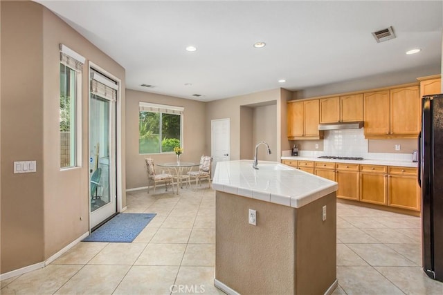83315 Stagecoach Rd, Indio, CA 92203 - kitchen featuring under cabinet range hood, freestanding refrigerator, light tile patterned floors, tile countertops, and recessed lighting