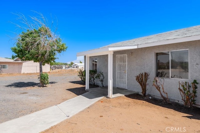 16233 Manzanita St, Hesperia, CA 92345 - view of exterior entry with stucco siding and a patio area