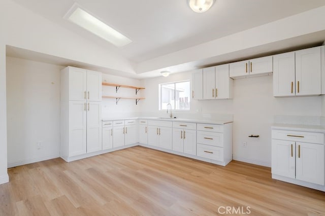 16233 Manzanita St, Hesperia, CA 92345 - kitchen featuring white cabinetry, open shelves, light wood-type flooring, light countertops, and lofted ceiling