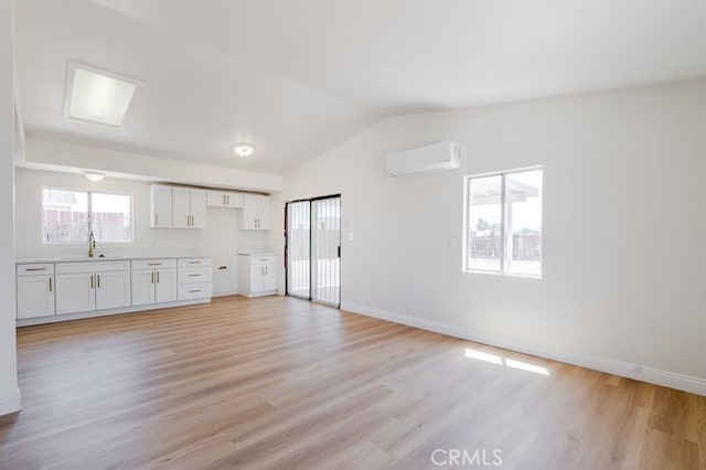 16233 Manzanita St, Hesperia, CA 92345 - unfurnished living room featuring a wall mounted AC, lofted ceiling, and light wood finished floors