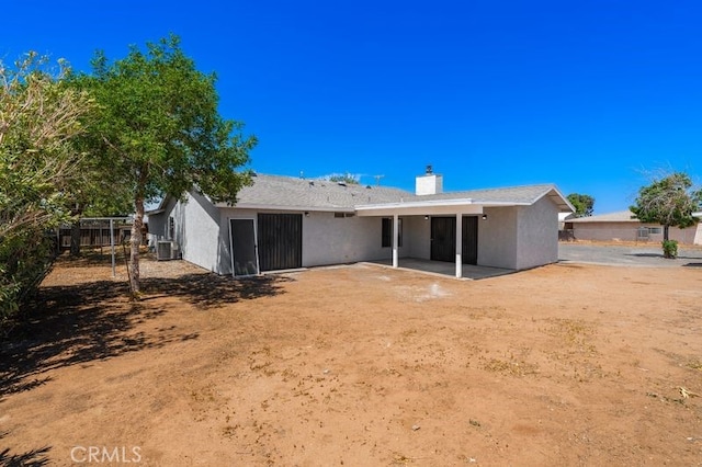 16233 Manzanita St, Hesperia, CA 92345 - back of property with a patio area, stucco siding, and a chimney