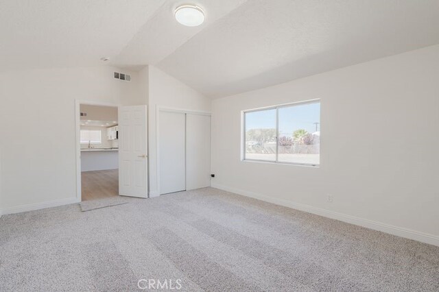 16233 Manzanita St, Hesperia, CA 92345 - unfurnished bedroom with light colored carpet, lofted ceiling, and a closet