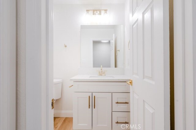 16233 Manzanita St, Hesperia, CA 92345 - half bathroom with vanity and wood finished floors