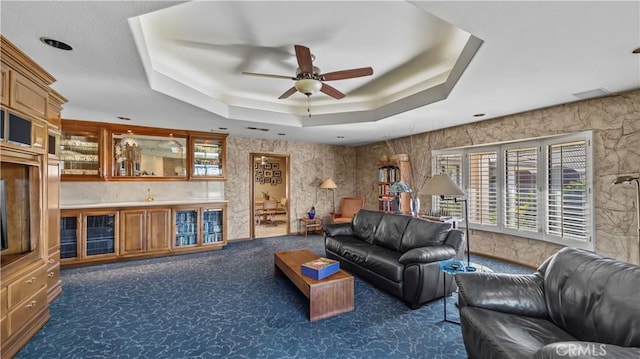 4968 Chapala Dr, Riverside, CA 92507 - living room with a ceiling fan, plenty of natural light, a tray ceiling, and dark colored carpet
