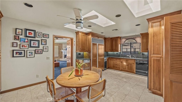4968 Chapala Dr, Riverside, CA 92507 - kitchen featuring black dishwasher, a skylight, paneled built in refrigerator, ceiling fan, and brown cabinetry