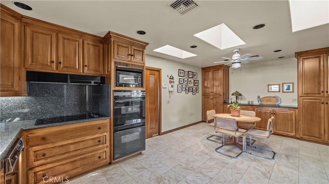 4968 Chapala Dr, Riverside, CA 92507 - kitchen featuring a skylight, black appliances, brown cabinetry, decorative backsplash, and recessed lighting