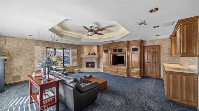 4968 Chapala Dr, Riverside, CA 92507 - living area with a fireplace, a ceiling fan, dark colored carpet, and a raised ceiling