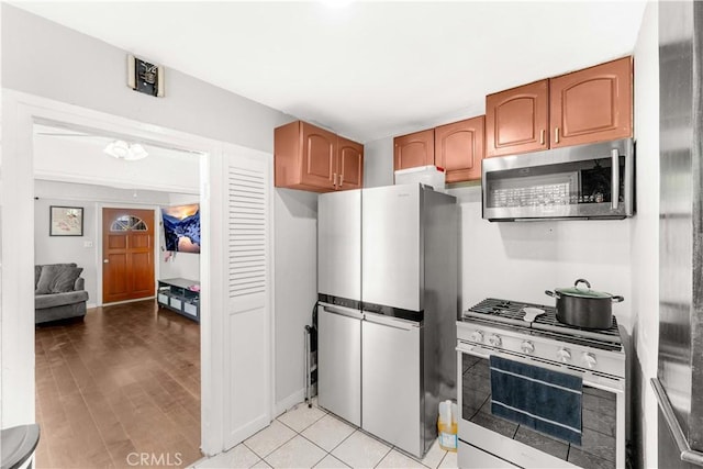 629 E 93rd St, Los Angeles, CA 90002 - kitchen with appliances with stainless steel finishes, brown cabinetry, and light wood finished floors