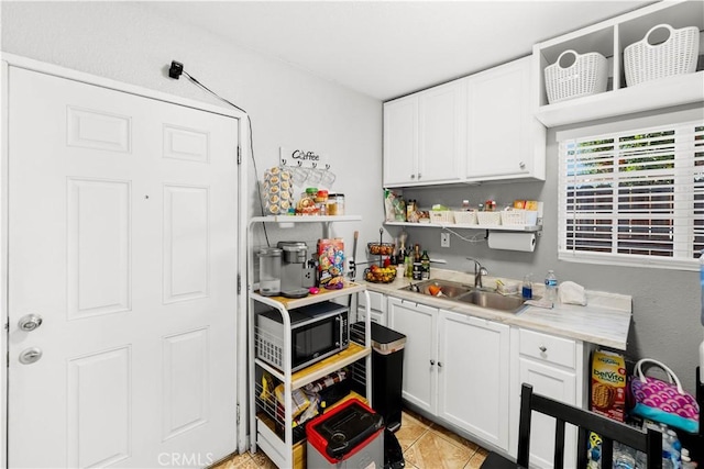 629 E 93rd St, Los Angeles, CA 90002 - kitchen with open shelves, white cabinets, light countertops, and light tile patterned floors