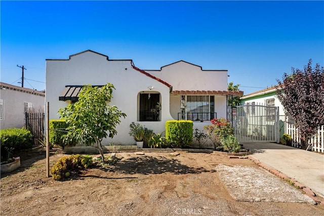 629 E 93rd St, Los Angeles, CA 90002 - mediterranean / spanish home featuring stucco siding and a gate