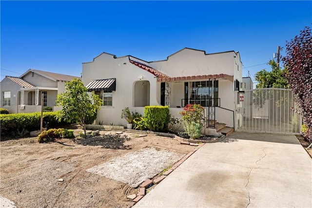 629 E 93rd St, Los Angeles, CA 90002 - mediterranean / spanish home featuring stucco siding, a gate, and a tile roof