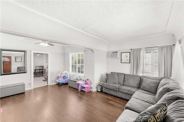 629 E 93rd St, Los Angeles, CA 90002 - living room featuring a textured ceiling, a ceiling fan, wood finished floors, and a wall mounted air conditioner