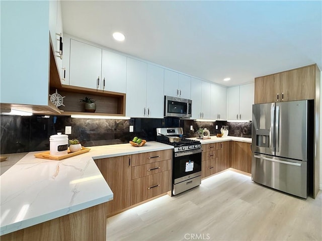 1319 Riedel Ave, Fullerton, CA 92831 - kitchen featuring appliances with stainless steel finishes, light stone counters, light wood-style flooring, decorative backsplash, and open shelves
