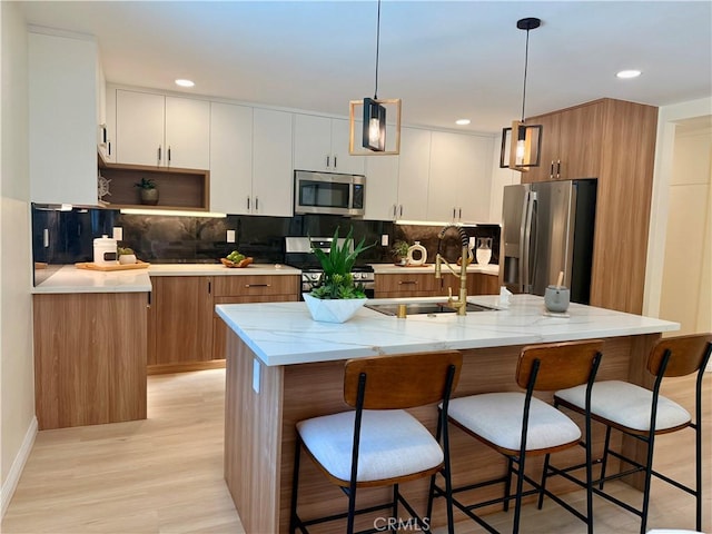 1319 Riedel Ave, Fullerton, CA 92831 - kitchen featuring stainless steel appliances, backsplash, a breakfast bar area, and recessed lighting