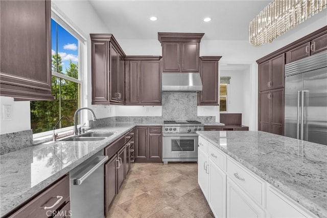 65 Rexford, Irvine, CA 92620 - kitchen with premium appliances, under cabinet range hood, light stone counters, recessed lighting, and dark brown cabinets