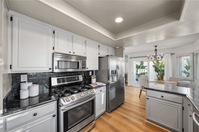 747 Highland View Dr, Corona, CA 92882 - kitchen featuring stainless steel appliances, a chandelier, light wood-style flooring, decorative backsplash, and dark stone counters