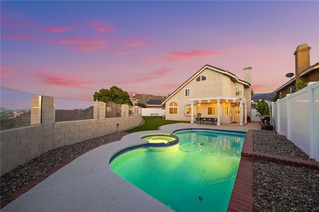 747 Highland View Dr, Corona, CA 92882 - pool at dusk with a fenced backyard, a pool with connected hot tub, and a patio