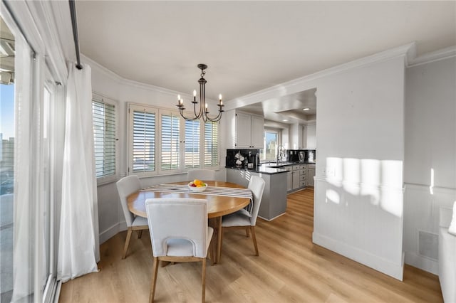 747 Highland View Dr, Corona, CA 92882 - dining area with crown molding, a chandelier, and light wood-style flooring