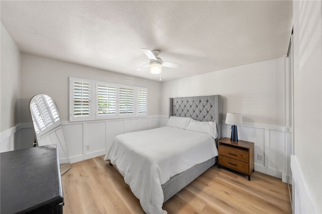 747 Highland View Dr, Corona, CA 92882 - bedroom with a wainscoted wall, light wood-type flooring, a textured ceiling, a ceiling fan, and a decorative wall