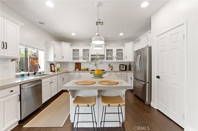 23004 Seattle Ridge Rd, Wildomar, CA 92595 - kitchen with stainless steel appliances, decorative backsplash, a center island, light countertops, and white cabinets