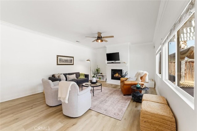 23004 Seattle Ridge Rd, Wildomar, CA 92595 - living area featuring light wood finished floors, ceiling fan, ornamental molding, and a glass covered fireplace