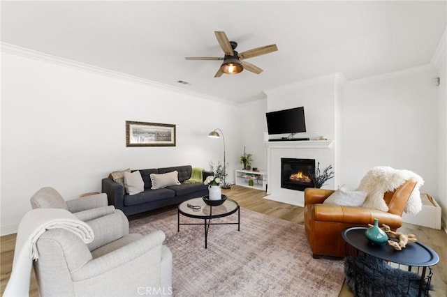 23004 Seattle Ridge Rd, Wildomar, CA 92595 - living area with wood finished floors, ornamental molding, ceiling fan, and a fireplace with flush hearth
