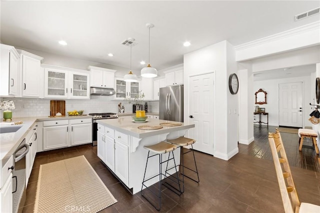 23004 Seattle Ridge Rd, Wildomar, CA 92595 - kitchen featuring appliances with stainless steel finishes, under cabinet range hood, decorative backsplash, light countertops, and recessed lighting