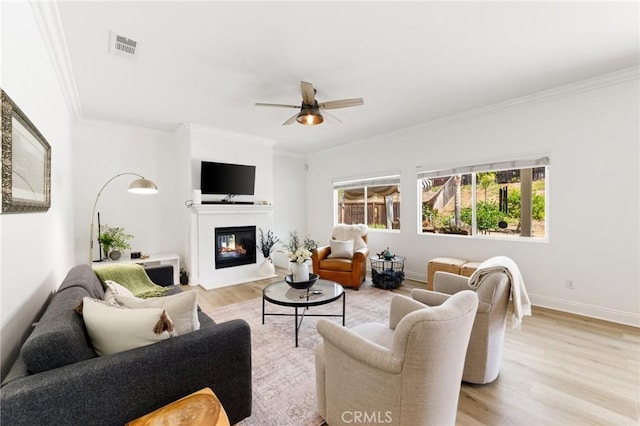 23004 Seattle Ridge Rd, Wildomar, CA 92595 - living room with light wood-style flooring, a glass covered fireplace, a ceiling fan, and crown molding