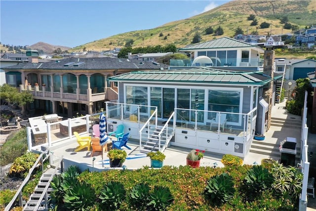 3436 Studio Dr, Cayucos, CA 93430 - rear view of house featuring a sunroom, a mountain view, stairs, and a metal roof