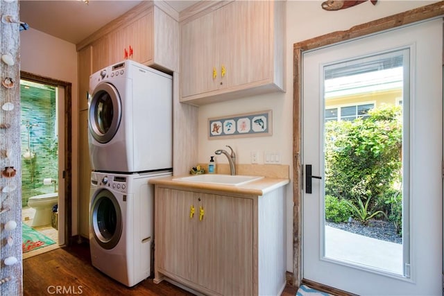 3436 Studio Dr, Cayucos, CA 93430 - laundry room featuring stacked washer and clothes dryer, cabinet space, and dark wood-style flooring