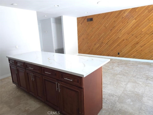 22127 Halsted St, Chatsworth, CA 91311 - kitchen with light stone counters, wood walls, and recessed lighting