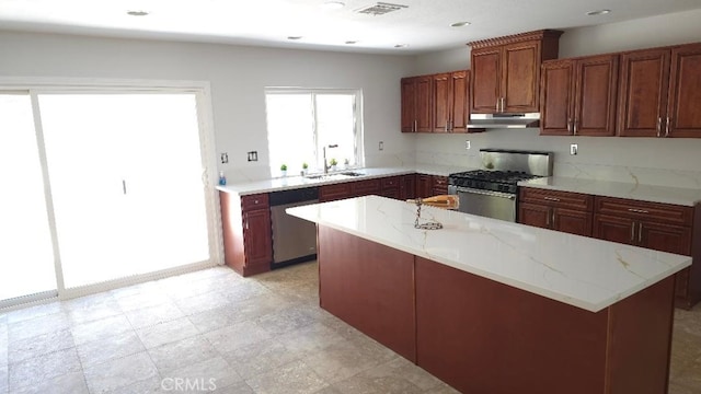 22127 Halsted St, Chatsworth, CA 91311 - kitchen featuring under cabinet range hood, appliances with stainless steel finishes, light stone counters, and a kitchen island