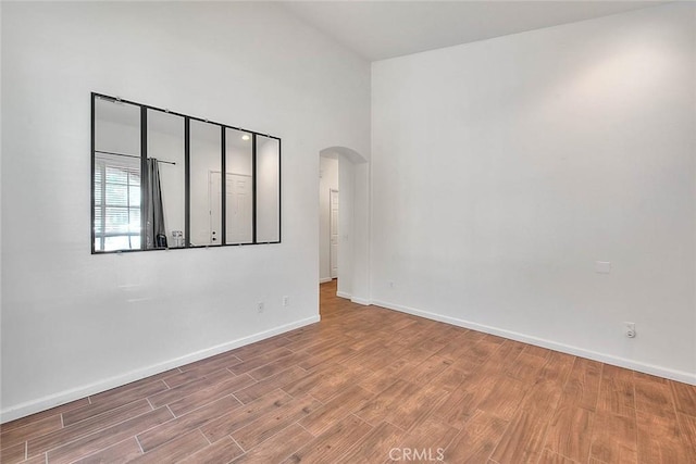 1503 Lynwood Way, Highland, CA 92346 - unfurnished room featuring arched walkways, wood finished floors, and a high ceiling