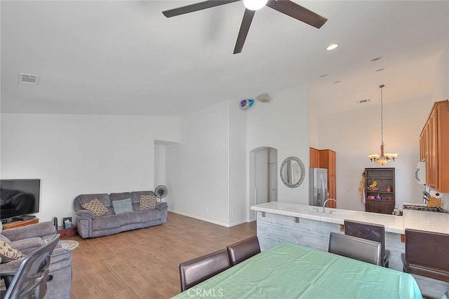 1503 Lynwood Way, Highland, CA 92346 - living room featuring a ceiling fan, a chandelier, arched walkways, wood finished floors, and high vaulted ceiling
