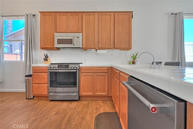 1503 Lynwood Way, Highland, CA 92346 - kitchen with stainless steel appliances, light wood-type flooring, healthy amount of natural light, and tile counters