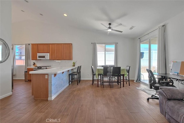 1503 Lynwood Way, Highland, CA 92346 - kitchen with white microwave, tile countertops, ceiling fan, a peninsula, and light wood finished floors