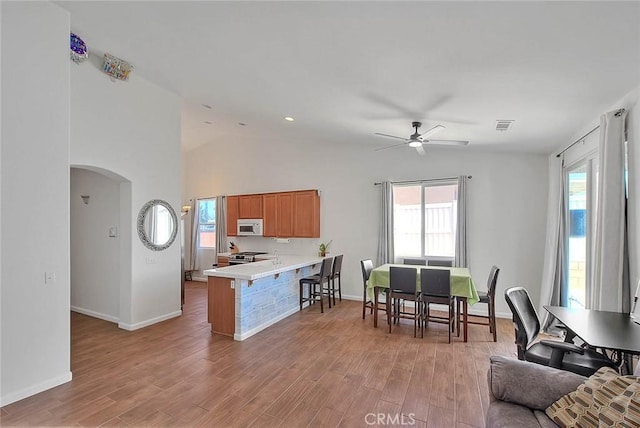 1503 Lynwood Way, Highland, CA 92346 - kitchen with white microwave, arched walkways, a ceiling fan, healthy amount of natural light, and vaulted ceiling