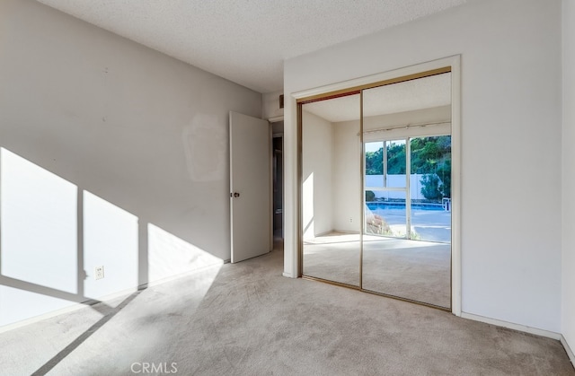 27909 Alaflora Dr, Rancho Palos Verdes, CA 90275 - unfurnished bedroom featuring carpet flooring, a closet, a textured ceiling, and access to exterior