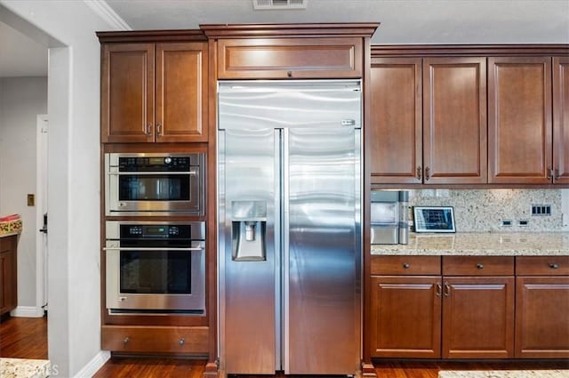 22517 Skipping Stone Dr, Saugus, CA 91350 - kitchen featuring stainless steel built in refrigerator, dark wood-style flooring, light stone countertops, tasteful backsplash, and crown molding