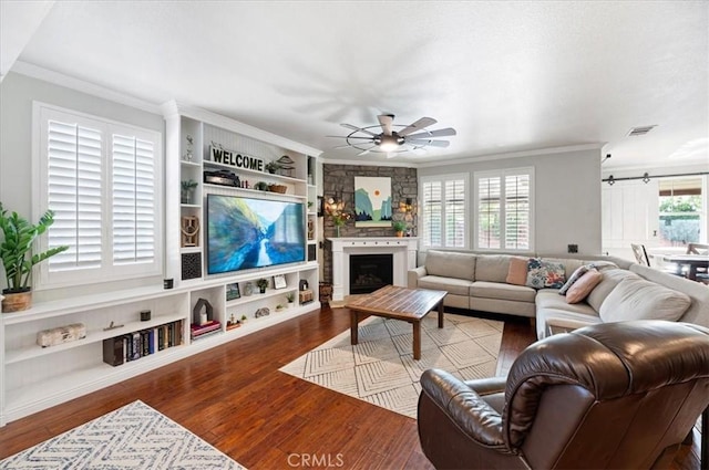 22517 Skipping Stone Dr, Saugus, CA 91350 - living room featuring crown molding, wood finished floors, a ceiling fan, a fireplace, and built in features