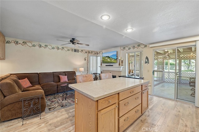 11361 Foxglove Ln, Corona, CA 92878 - kitchen with light wood-style flooring, a ceiling fan, open floor plan, light countertops, and a textured ceiling