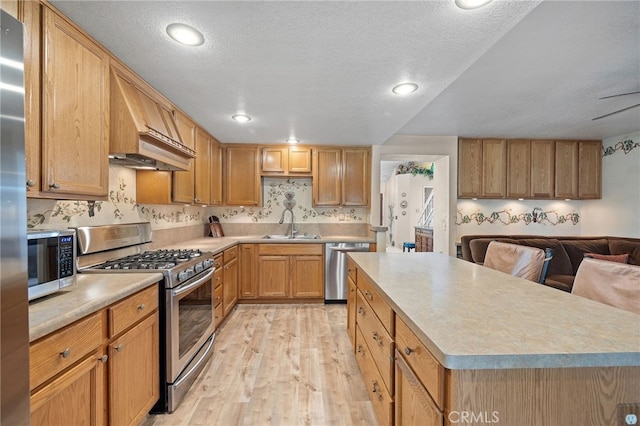 11361 Foxglove Ln, Corona, CA 92878 - kitchen with stainless steel appliances, light wood-style floors, light countertops, open floor plan, and a center island