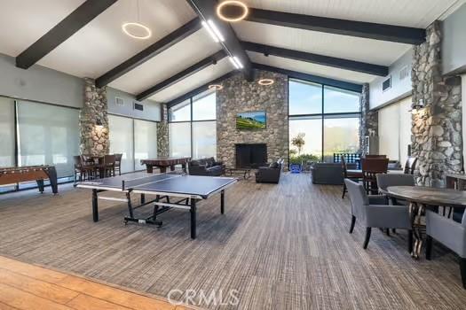 11361 Foxglove Ln, Corona, CA 92878 - recreation room with beamed ceiling, a fireplace, high vaulted ceiling, and wood finished floors