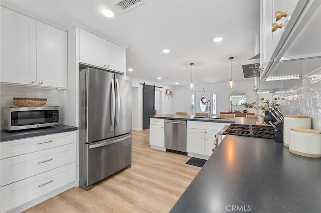 927 E Fairway Dr, Orange, CA 92866 - kitchen featuring stainless steel appliances, dark countertops, a barn door, white cabinetry, and recessed lighting