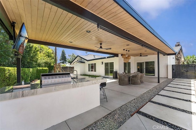 927 E Fairway Dr, Orange, CA 92866 - fenced backyard featuring a ceiling fan, an outdoor kitchen, exterior bar, and a patio